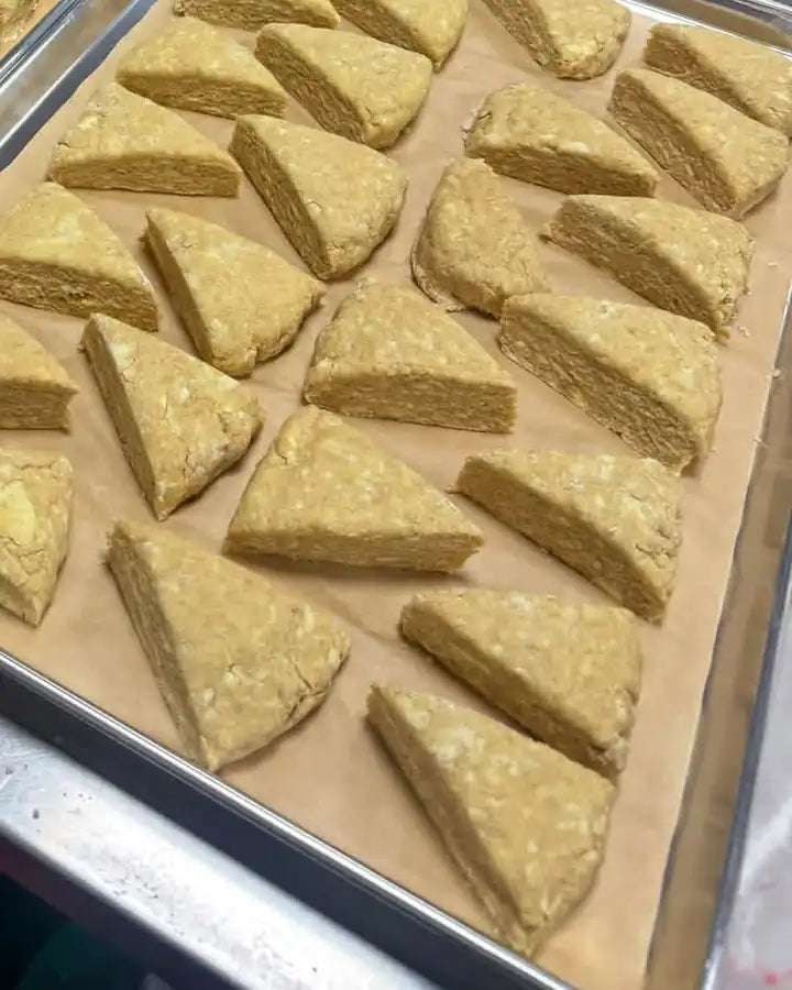 Hand-cut scones on a parchment-lined sheet tray in the Anchor & Rye kitchen, ready for the freezer