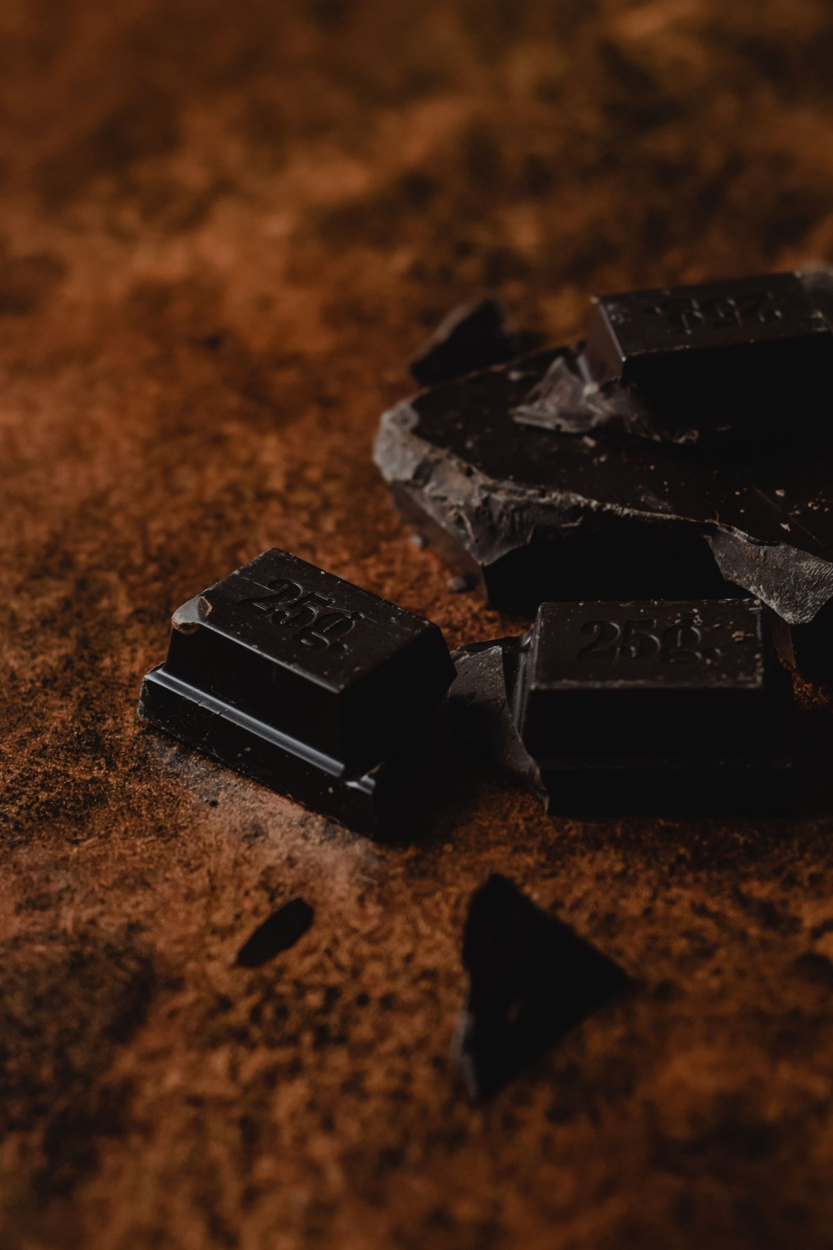 Dark chocolate pieces on cocoa powder